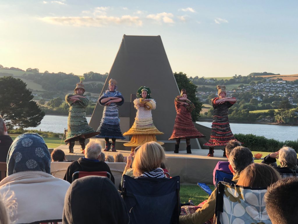 A photo of 5 actors on stage performing a play called The Perfect World with the River Teign in the background